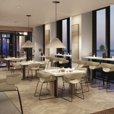 An elegant modern lounge with white marble tables, countertop seating, pendant lighting, and views of the Long Island Sound
